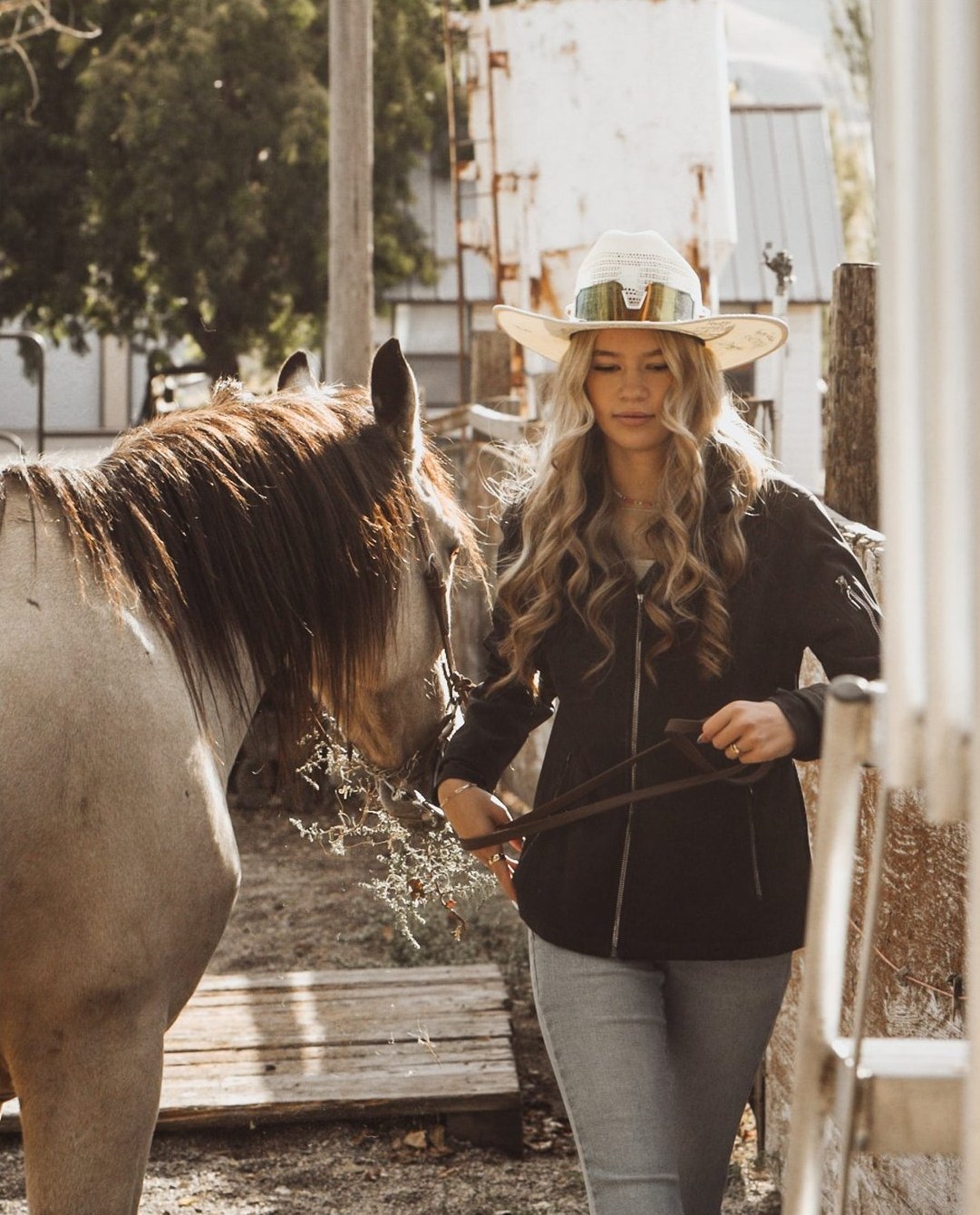 Kennedy in her cowboy hat, leading a horse